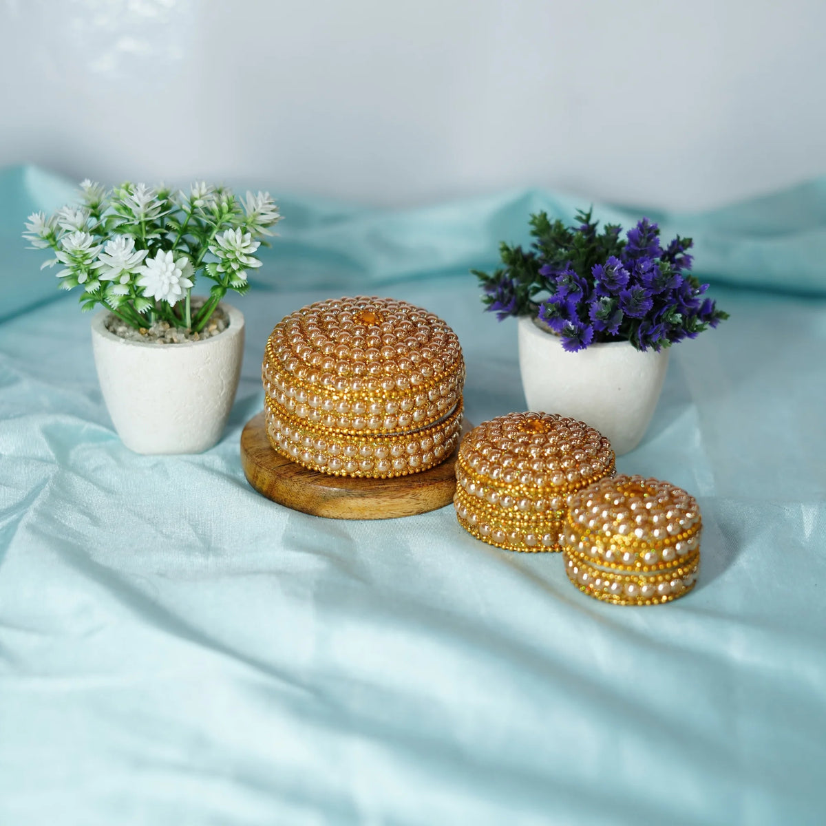 Three pearl-beaded pujan dibbi boxes in graduated sizes with gold-coloured bead trim