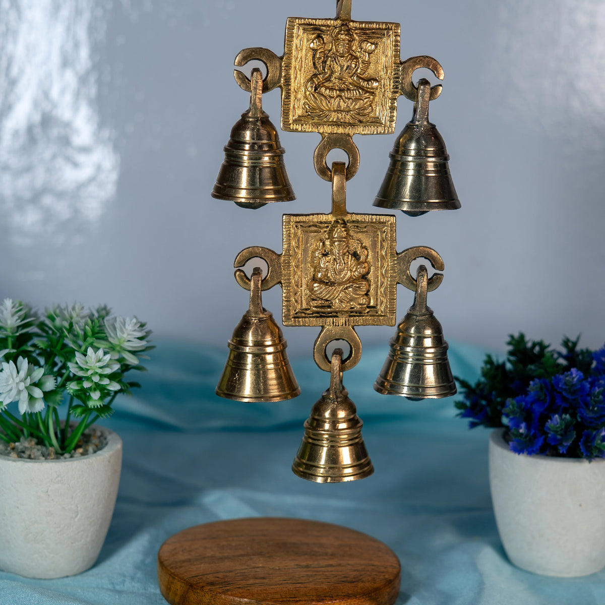 Close view of the brass hanging with Maa Laxmi and Ganesh plaques and five ridged bells